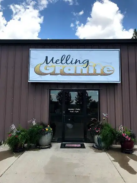 Melling Granite shop front on Westview Drive in Cedar City, with a gold and black sign over glass doors and flower planters